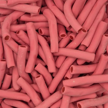 A clear plastic square container filled with many small pink cylindrical pieces, photographed from above on a plain light background.
