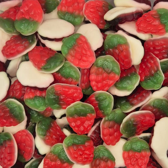 A clear plastic container filled with strawberry-shaped candies, photographed from above on a plain light background.