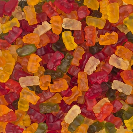 A clear plastic square container filled with assorted colorful gummy bears, photographed from above on a white surface.