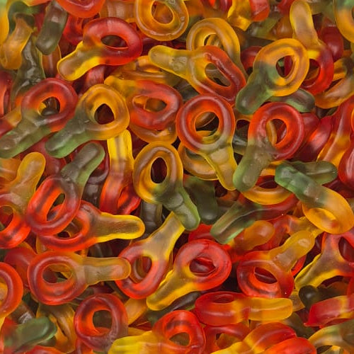 A clear plastic container filled with many small gummy candies shaped like rolled-up rings in red, orange, yellow, and green, photographed from above on a white surface.