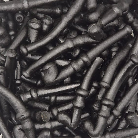 A clear plastic container filled with many dark metal bolts or screws, photographed from above on a white surface.