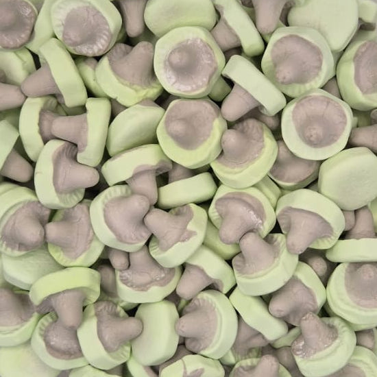 A clear plastic container filled with small mushroom-shaped items, likely bath salts or decorative bath bombs, in pale green and grayish-brown tones, set against a plain light background.