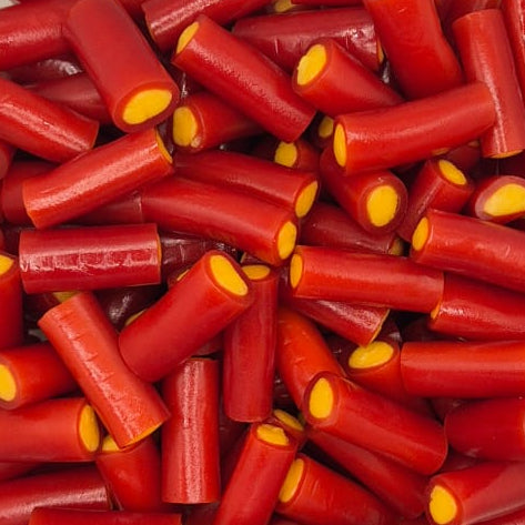 A clear plastic tub filled with red cylindrical items, each with a small yellow circular detail at one end, photographed from above on a white surface.