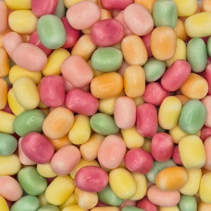 A close-up pile of small, smooth, capsule-shaped  Swedish candies in pastel pink, yellow, green, and orange.
