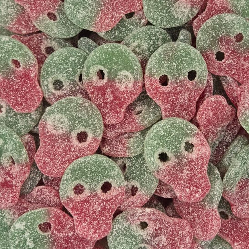 A clear plastic container filled with small round candy pieces coated in pink and green sugar, photographed from above on a white surface.
