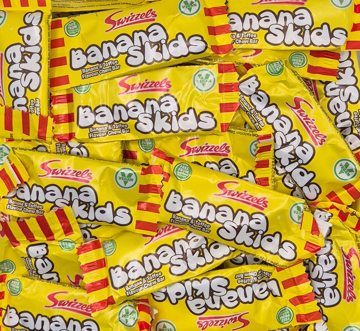 A pile of Swizzels Banana Skids candy bars on a white background.