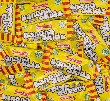 A pile of Swizzels Banana Skids candy bars on a white background.