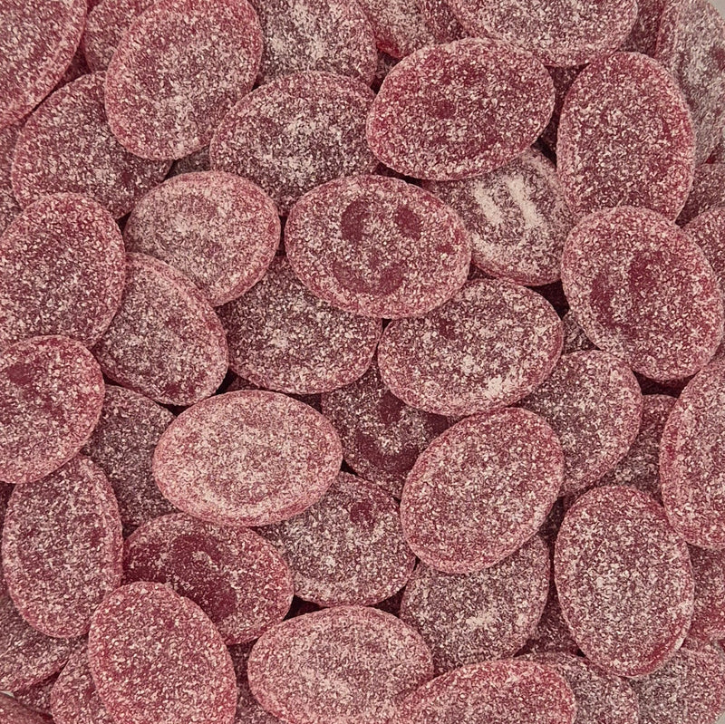A close-up pile of oval pink candy-coated chocolates or gummies, coated in a fine white sugar dusting. Picture of S -Märke , the famous Swedish Candy