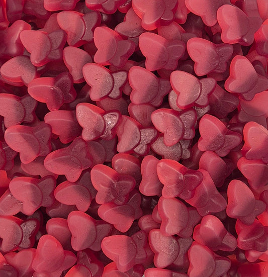 A dense pile of small, glossy, heart-shaped pink candies or gummies filling the entire frame.