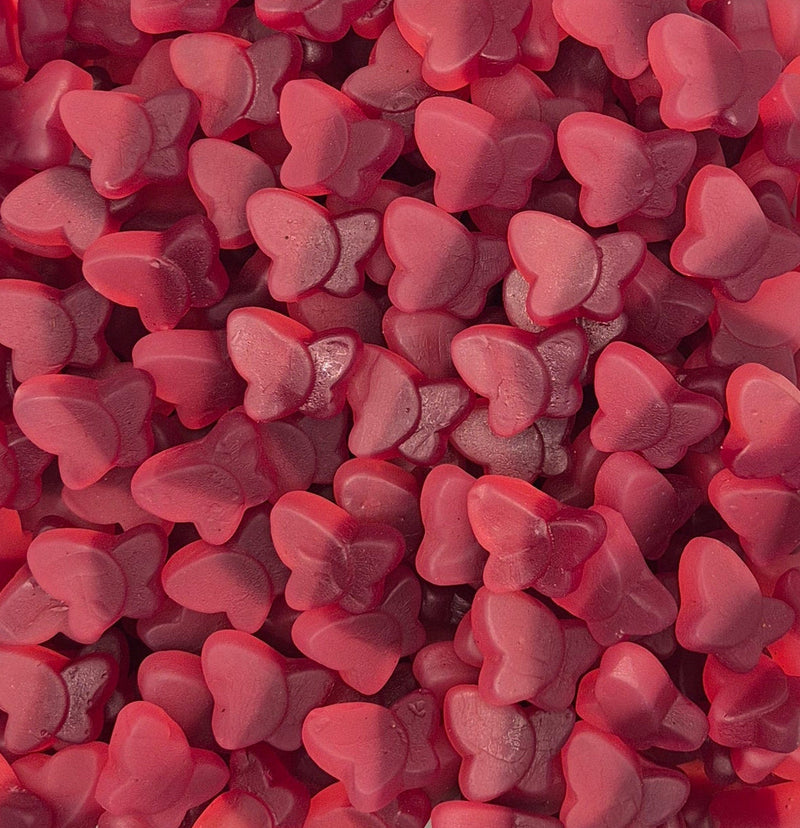 A dense pile of small, glossy, heart-shaped pink candies or gummies filling the entire frame.