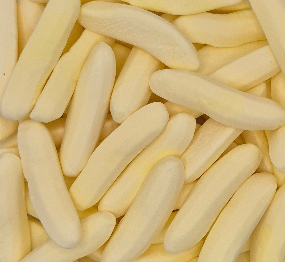 A close-up pile of pale yellow, curved, stick-like pieces, likely wax melts or soap bars, filling the entire frame.