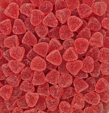 A close-up, top-down view of many small, heart-shaped red gummy candies with a frosted sugar coating, filling the entire frame.