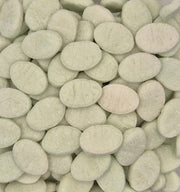 A close-up pile of oval, sugar-coated tablets or candies in a very pale mint green color, filling the entire frame.